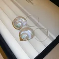 Elegant pearlescent nautilus shell hoop earrings on a cream velvet jewelry box display - 19# Conch Hoop Style