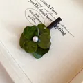 Detailed macro shot of a green layered flower hair clip with center pearl - Duckbill Clip (HH8951) / Green