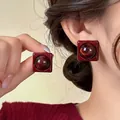 Nahaufnahme von quadratischen Vintage-Ohrsteckern aus rotem Harz am Ohr einer Frau. - Tiefroter Geometrischer Harzstecker (94#) / Rot