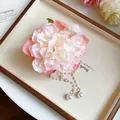 Close-up of elegant fabric flower hair claw clip with delicate pearl tassel accents - Hair Claw / Pink