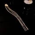 Elegant gold geometric ear cuff featuring multiple long hanging tassel chains detail view - Single Piece / Gold