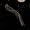 Detailed shot of irregular geometric silver ear cuff with long multi-strand chain tassels - Single Piece / Silver