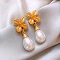 Dettaglio di orecchini vintage con perle a goccia e fiori dorati su seta. - 31# Stile Fiore in Metallo a Quattro Petali