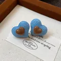 Detailansicht der Herz-Ohrstecker mit blauem Denim-Stoff und braunem Harz-Herzchen - Kaffeeblau
