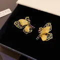 Nahaufnahme von eleganten Vintage-Ohrsteckern in Schmetterlingsform mit Strasssteinen - Schmetterling Stil (HE23820) / Gold (Violette Strass)
