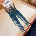 Detail view of geometric tassel earrings with blue and green zircon stones in a box - 13# Silver Needle - Blue - Triangle