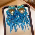 Close-up of vintage palace style blue tassel earrings with rhinestones and beads. - 28# Silver Pin - Blue