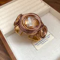 Dettaglio macro di bracciale bohémien avvolto in filo con pietra di vetro ambrata - Pietra Rotonda / Oro
