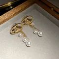 Close-up of 18k gold plated zircon oval earrings with pearl tassels in jewelry box - Oval Rose Pearl Tassel Style (HE31191) / Gold