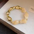 Dettaglio di una collana di perle irregolari in acrilico e oro in stile vintage - Oro-Bianco