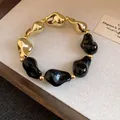 Elegante bracciale stile vintage con perle acriliche irregolari color oro e nero - Oro-Nero