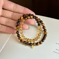 Elegant hand holding tiger's eye and citrine crystal beaded bracelets with gold charm - Citrine Tiger Eye Stackable Style(75) / Stackable
