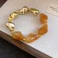 Elegante bracciale retrò con perle irregolari in acrilico ambrato e grani dorati - Oro-Caffè chiaro