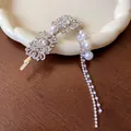 Détail d'une pince à cheveux de luxe en strass avec d'élégants pompons en perles artificielles - Pince à Cheveux (Unique) / Argent