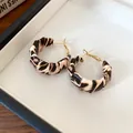 Primer plano de pendientes de aro envueltos en cuero con estampado de leopardo en bandeja blanca. - Redondo (3mm)