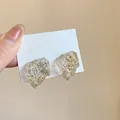 Irregular resin stud earrings with gold and silver foil flakes on white display card. - White