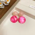 Detailed close-up of pink and fuchsia resin drop earrings with a vintage marbled finish. - Geometric Pendant (HE26338) / Pink