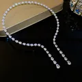 Vue détaillée d'un collier luxueux en zircons en forme de goutte sur surface sombre. - Argent