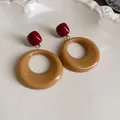 Close-up of retro Maillard brown and red resin hoop earrings on a white plate. - Round Style