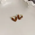 Detailed close-up of glossy Maillard brown heart-shaped earrings with elegant gold hooks - Matte Heart Style