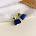 Detaillierte Ansicht geometrischer Ohrstecker mit blauen und grünen geschliffenen Steinen - Gold-Grün-Blau