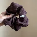 Close-up of a vintage brown striped fabric scrunchie showing detailed texture and design - Red