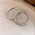 Gros plan détaillé de boucles d'oreilles créoles en métal argenté à texture spirale. - Créoles argentées à motif en spirale (28#) / Argent