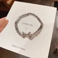 Dettaglio del bracciale in argento con zirconi e fiocco scintillante su cartoncino. - 32# Braccialetto in zirconia design fiocco (WB941) / Argento