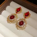 Detailed view of vintage style gold filigree earrings featuring large red gemstones - 60# Silver Pin - Gold - Red