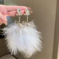 Detailed close-up of elegant white feather tassel earrings featuring rhinestone bow accents - White Bowknot Feather Style (HE15591)