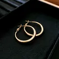 Elegant gold polished hoop earrings with minimalist circular design in jewelry tray. - Small Size (3#)