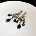 Détail de boucles d'oreilles vintage à pompons avec cristaux noirs et aiguilles argent - Style de Gland Vintage (HE13633) / Noir