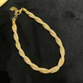 Makroansicht der filigranen italienischen Geflechtstruktur dieses goldfarbenen Schmuckstücks - Gewickelt Verdrehter Stil / Gold