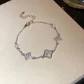 Nahaufnahme eines eleganten silbernen Zirkon-Kleeblatt-Armbands auf einer Textur. - Silber Kleeblatt Anhänger Stil (HB5181)
