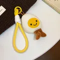 Detailed view of a cute plush fried egg keychain featuring a smiley face and yellow cord loop - White, Yellow
