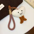 Close-up of cute plush heart pendant keychain with smiling face and braided cord loop. - Brown, White