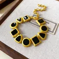 Detail view of a vintage court style necklace with geometric black enamel charms - Bracelet / Gold-Black