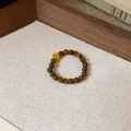 Vue détaillée d'une bague en perles d'œil de tigre ornée d'un charmant pendentif de pièce - Bague en Perles Pendentif Pièce (2#)