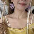 Primo piano di orecchini a sospensione con fiori di perline viola indossati da una donna - Stile 4(4#)