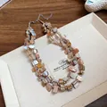 Macro view of a double-layer irregular shell necklace with a bohemian vintage design - Off White