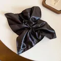 Macro detail showing the premium faux-leather texture of the vintage black square scrunchie - Black