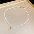 Primo piano di un'elegante collana di perle con ciondolo ovale in pietra occhio di gatto. - Stile Pietra Occhio di Gatto Ovale Verde (HN3215)