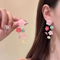 Dettaglio di orecchini pendenti con fiori e perline indossati dal modello - Stile 14(14#)