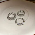 Vista dettagliata di un set di anelli regolabili argentati con cuori e strass - Argento (Set da 3 pezzi)