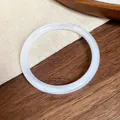 Macro detail of a vintage off-white acrylic acetate bangle with cloudy marble texture. - White