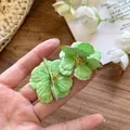 Eleganti orecchini a lobo a fiore verde chiaro con petali a strati e stami dorati in mano - Stile 54 (54#)