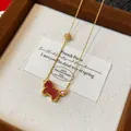 Detailed shot of a vintage gold zircon necklace with a red horse pendant in a gift box. - Necklace / Gold-Red