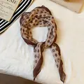 Detailed close-up view of a vintage brown floral printed silk-like scarf neckpiece. - Coffee-Flower