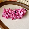 Primer plano de una elegante pinza para el pelo con flores de tela rosa y textura real - Estilo de Flores de Tela (51) / Rosa