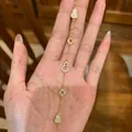 Gold-toned charm bracelet with gourd and coin motifs held by an Asian model's hand - Coin Pendant Style (41#) / Gold